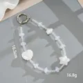Close-up van de 16,5 cm lange kralenketting voor telefoon met hart- en stermotieven. - Telefoonaccessoire (K6422) / Wolk Strik Hart Hanger Wit