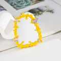 Detail shot of yellow liquid drip mirror charm with pink gems for DIY phone case - Yellow