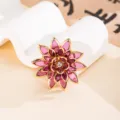 Dettaglio ravvicinato di un accessoire a fiore in acrilico viola con strass brillante - Viola