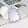 Dettaglio di un accessorio specchio fluido viola con gemme rosa per decorazione DIY - Viola