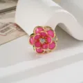 Primo piano del charm a forma di camelia rosa con petali in acrilico e strass lucido - Rosso rosa