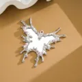 Detailed view of an irregular liquid metal butterfly mirror pendant with pink gemstones. - Butterfly Gemstone Mirror Ornament (D3499) / Silver