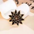 Dettaglio macro di fascino a fiore in acrilico nero con finitura dorata - Nero