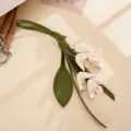 Detailaufnahme eines grün-weißen Taschenanhängers aus PU-Leder in Lilienform für Damen - 金桂花皮革挂件(K6363)
