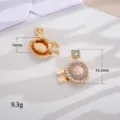 Nahaufnahme von goldenen Parfümflaschen-Manschettenknöpfen mit Perlenverzierung - Parfümflasche / Rosa