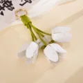 Detaillierte Makroansicht des Schlüsselanhängers aus weißem Leder mit grünen Tulpenknospen - 郁金香皮革挂件(K6353)