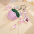 Close-up detail of a cute PU leather peach bag charm with various puppy acrylic pendants - Peach Origami Crane Pendant (K1752) / Purple