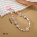 Vista detallada del cordón para teléfono hecho a mano con cuentas de mariposa, 16.3cm - Colgante Mariposa con Bola de Cristal