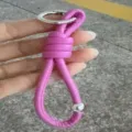 Handmade hot pink braided leather cord keychain with silver bead and circular metal ring - Rose Red