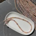 Détail de perles d'eau douce couleur bonbon de 6-6,5 mm avec un éclat vif sur une assiette blanche - Longueur env. 39cm 60 pcs / Couleur Bonbon Naturel