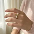 Nahaufnahme eines eleganten Süßwasserperlenrings mit Goldmünzenanhänger am Finger - Münze Perle Stil (R198) / Elastisch Verstellbar