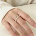 Detailansicht eines elastischen Süßwasserperlenrings mit goldenem Blumenanhänger. - Elastischer Ring / Strass Blumen-Stil (R195)