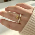 Detaillierte Ansicht eines Naturperlenrings mit drei kleinen goldenen Münzanhängern - Glücks Segen Perle Stil (R184) / Elastisch Verstellbar