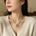 Collar con colgante de Thangka Tara Verde tibetano con perlas y lapislázuli en modelo. - Funda de Thangka Tara Verde, oro