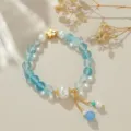 Nahaufnahme Detail des neuen chinesischen blauen Kristall und Perlen Armbands mit Goldblume. - Blau Rutilquarz Stil / Blau