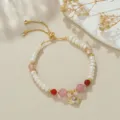 Nahaufnahme des verstellbaren Süßwasserperlen und Erdbeerkristall Armbands mit Engelsherz. - Natürliche Perle Herz Flügel Rosa Quarz Armband
