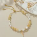 Nahaufnahme des verstellbaren Perlenarmbands mit goldenem Schlüssel und Herz-Anhänger. - Natürliche Perle Herz Schlüssel Topas Armband