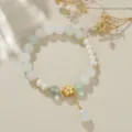 Elegantes Süßwasserperlen Armband mit grüner Kristallperle und goldenem Blumenanhänger. - Abakus Weißer Jade Stil
