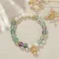 Nahaufnahme Detail der chinesischen Süßwasserperle und bunten Kristall Perlenarmband mit Glocke. - Grüner Phantomquarz-Stil