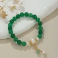Detailaufnahme des grünen Perlenarmbands mit Süßwasserperlen und goldenen Elementen auf Keramikteller. - Naturperle Grüner Achat Armband (B4206)