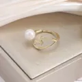 Korean style open metal ring featuring a smooth pearl and elegant line heart design. - Gold