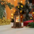 Christmas water globe lantern detail view with glowing snowman scene and holiday decor. - Snowman Style