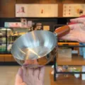 Stainless steel mini pot detail view showing smooth metallic interior and wooden handle design. - No Lid / 14cm