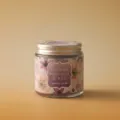Detail close-up shot of glass jar scented candle featuring floral label and metal lid. - Cherry Blossom & Gulf