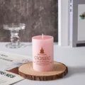 Primo piano dettagliato di una candela profumata cilindrica rosa su supporto in legno. - 5*5CM / Rosa