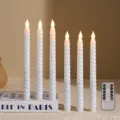 Close-up of elegant white twisted LED taper candles with remote control on a decorative book. - White Threaded Long Pole Flame Tip Remote Control Version / White