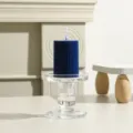 Detailansicht einer dunkelblauen gerippten Stumpenkerze auf transparentem Glasleuchter. - 5cm*7.5cm / Klein-Blau
