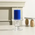 Nahaufnahme Detailansicht einer blauen gerippten Stumpenkerze auf einem klaren Kerzenhalter. - 5cm*7.5cm / Marineblau