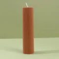 Detalle de vela perfumada de pilar acanalado marrón que muestra superficie y cera. - 5 cm * 20 cm / Café