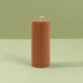 Primer plano detallado de una vela de pilar marron estriada con diseño de columna. - 5cm*12.5cm / Marrón