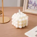 Primer plano detallado de una vela electrónica de cubo de burbujas blanca en mesa. - Vela LED cubo burbuja bala