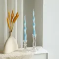 Close-up detail of light blue twisted long soy wax scented candle in crystal glass holder. - Sky Blue