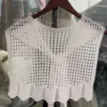 Nahaufnahme eines weissen gestrickten Schals mit feiner Häkelstruktur und wiegendem Saum. - Weiß