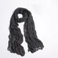 Detail shot of a dark grey crinkled solid color scarf, lightweight voile wrap for women. - Gray