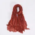 Detailed view of a solid rust red crinkled balisoz scarf, lightweight draped wrap for women. - Orange