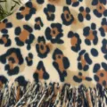 Nahaufnahme des stilvollen Leopardenmuster Schals aus Kaschmir Imitat mit weichen Fransen. - Schal-Stola mit Leopardenmuster in Orange und Kaffee