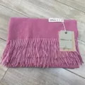 Detailaufnahme eines kuscheligen Winterschals mit Fransen, weiche Textur mit Markenetikett. - Altrosa Schals & Stolen