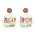Close-up detail of teacher appreciation wood earrings with motivational text round pendant. - Round Pendant Print Style (You Are KIND HELPFUL BRAVE...)