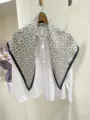 Dettaglio di un grande fazzoletto triangolare paisley bianco e nero con camicia bianca. - Sciarpa triangolare bianca a motivo paisley