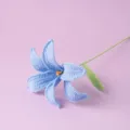 Handcrafted crochet lily flower detail shot showcasing intricate blue petals and green stem. - Blue