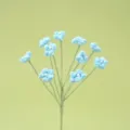 Nahaufnahme der handgearbeiteten blauen Häkel Schleierkrautblüte mit feiner Perle. - Blau