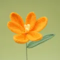 Close-up detail of handmade crochet orange flower with green leaf and stem for decor. - Orange