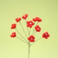 Handgemachte gehäkelte rote Blumen Zweig Detail mit Perle, gestrickte Pflanzen Deko Nahaufnahme. - Rot