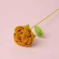 Handgemachte Häkelrose Detailansicht, exquisite gelbe Wollblume mit grünem Stiel und Blatt. - Dunkelgelb