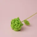 Nahaufnahme einer handgefertigten grünen Häkelrose mit Stiel, ideal als kreatives Geschenk. - Grün