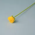 Handcrafted crochet yellow rose flower detail close-up view showing delicate green stem. - Yellow